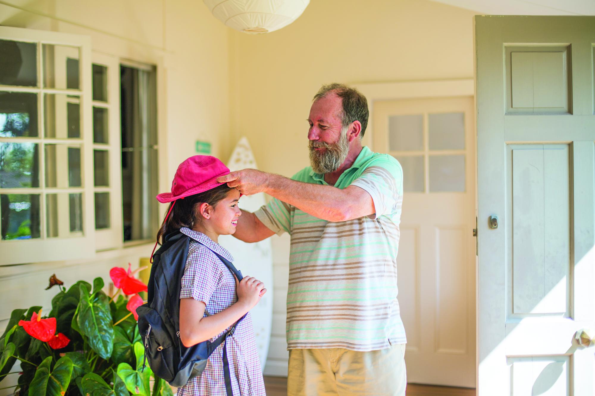 Grandad putting hat on child